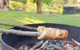Steckerlbrot braten über offenem Lagerfeuer