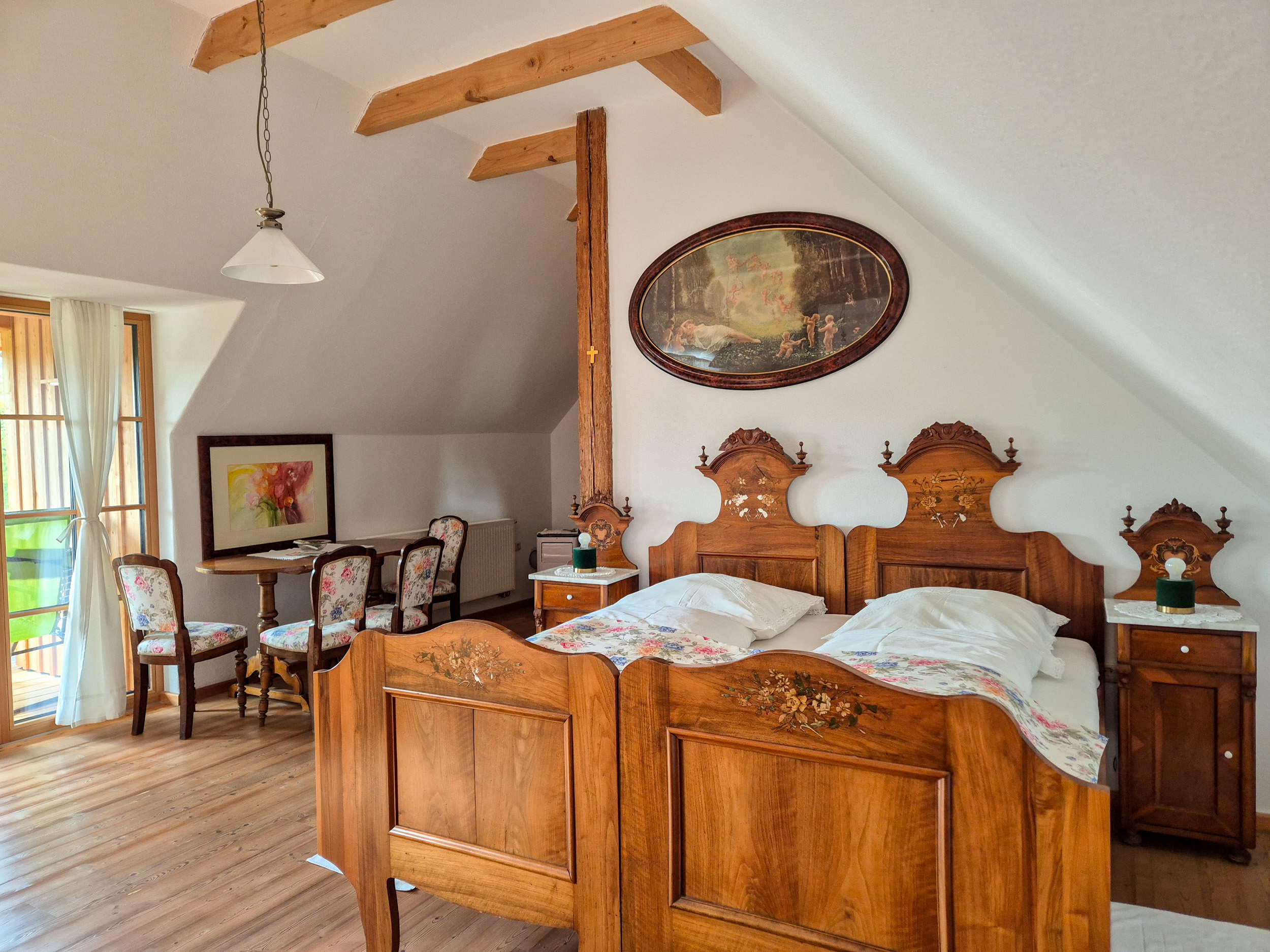 Double room Double bed made from wood with white bedlinens, in the background a dinner table with four chairs