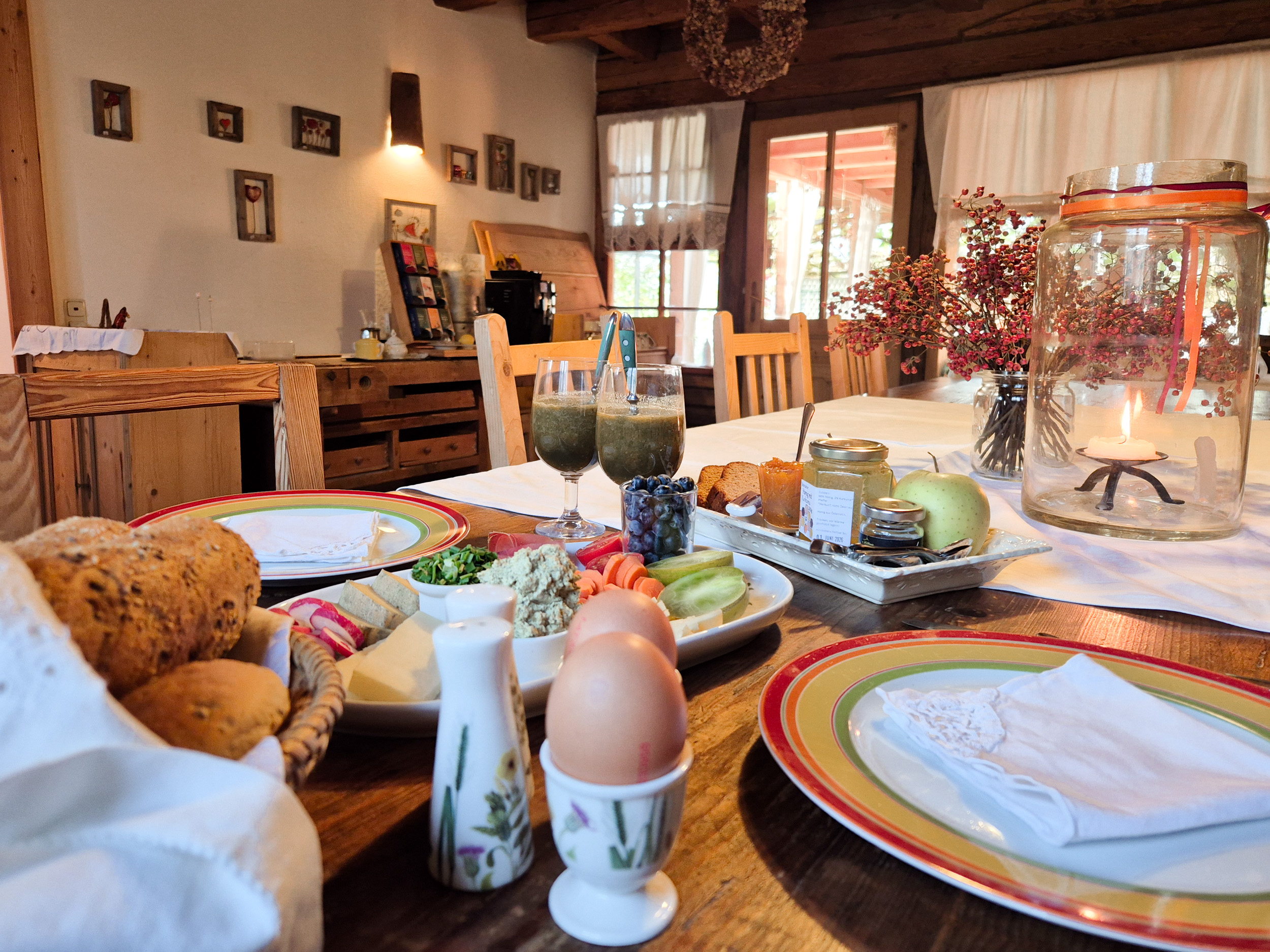 Auf einem großen Holztisch ist Frühstück für Zwei eingedeckt