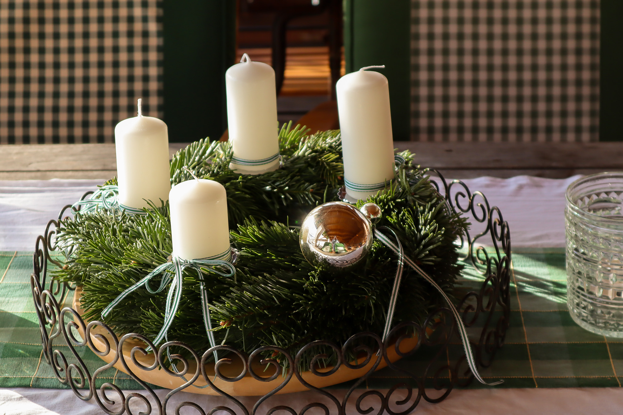 Adventkranz mit weißen Kerzen und frischem Tannengrün