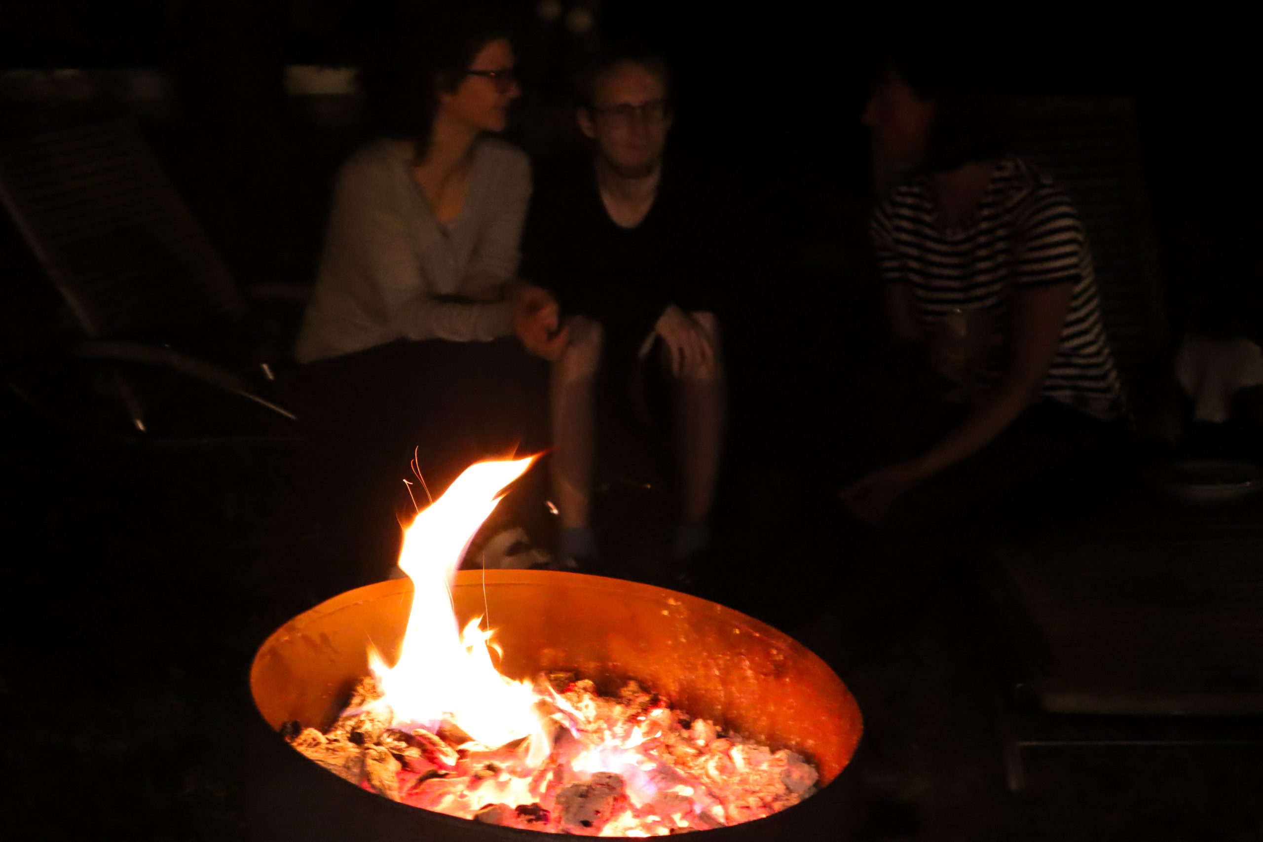 Flackerndes Lagerfeuer in einer Feuerschale im Innenhof des Sonnenhaus