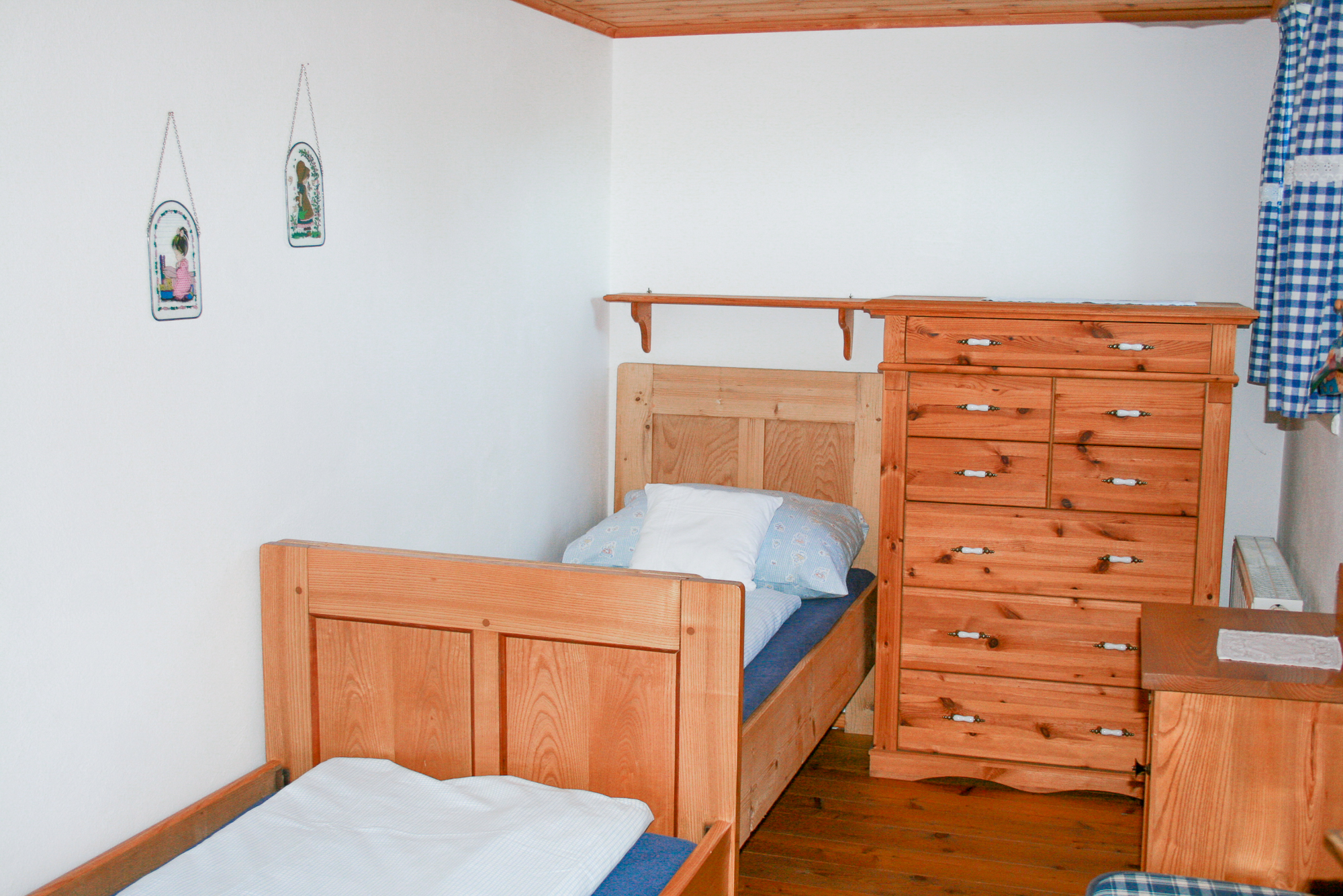 Zweibettzimmer mit Kommode in der Ferienwohnung Hereinspaziert