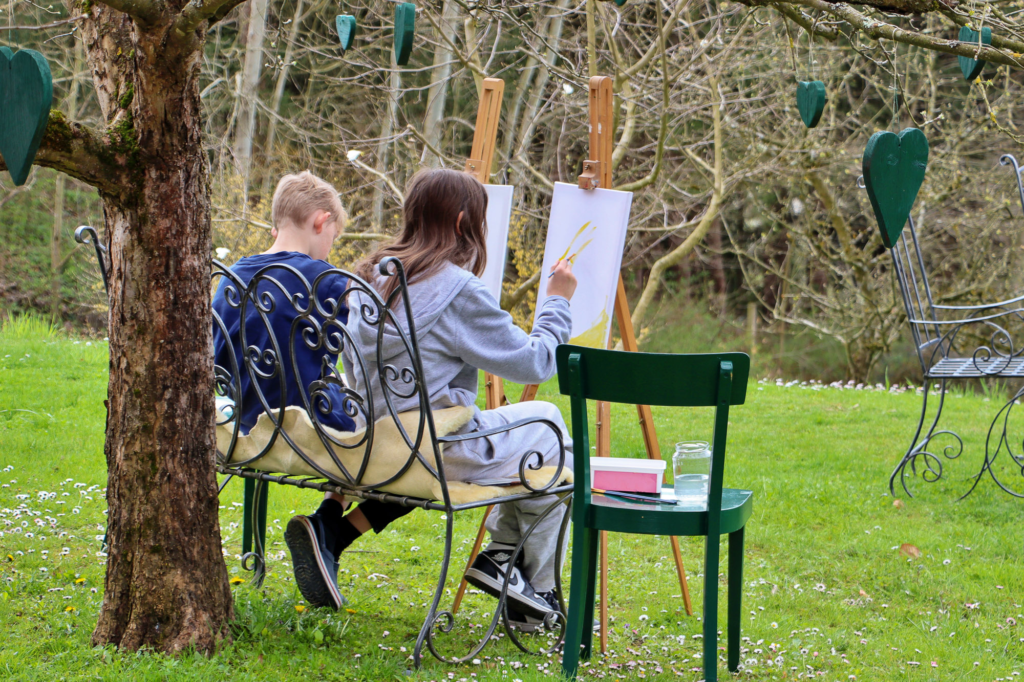 Kinder malen auf Staffeleien im Garten im Rahmen des Workshops Zeichnen und skizzieren