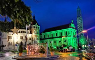 In grünes Licht gehüllte Kirche von Feldbach und das Rathaus Feldbach